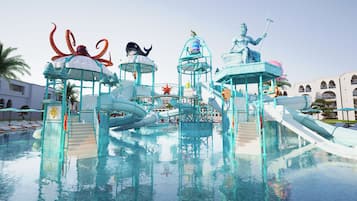A water park with slides and a statue of a mermaid.
