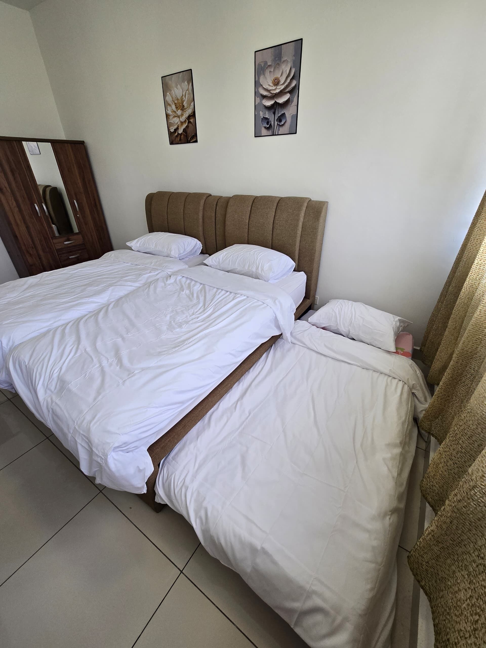 Un dormitorio con una cama grande, cabecera de madera y dos cuadros colgados en la pared.