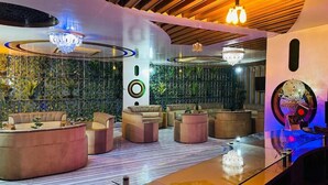 A modern lounge area with sofas and a bar counter, featuring a green wall with vertical gardens and ambient lighting. - Hotel Star Residence (Dhaka)