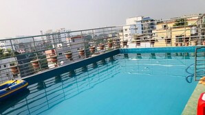 A rooftop swimming pool with a metal railing, surrounded by buildings. - Hotel Star Residence (Dhaka)