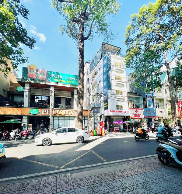 A street view with multiple storefronts, including a pharmacy and a hair salon.