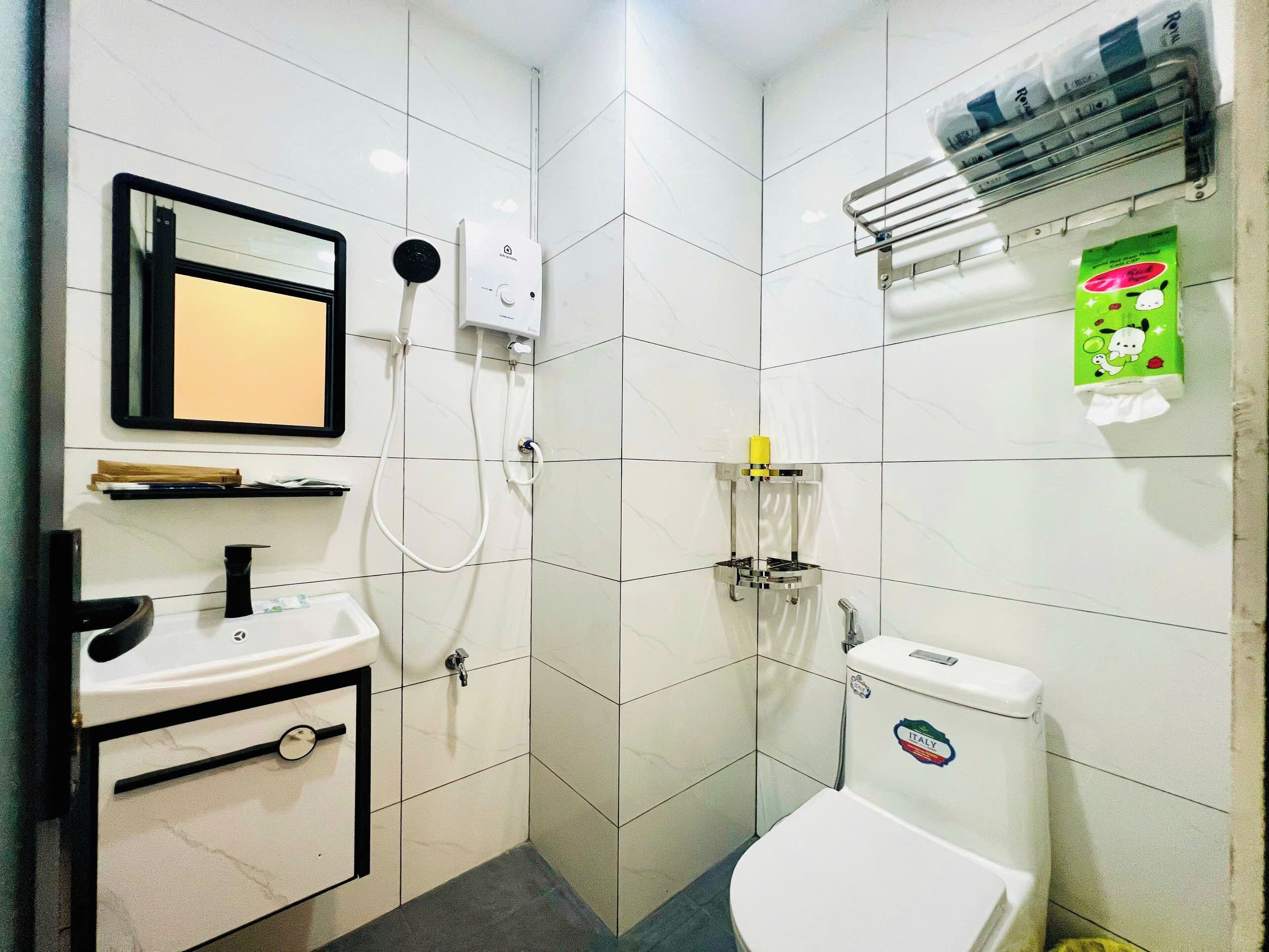 A bathroom with a toilet, sink, and shower.