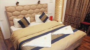 Una cama bien hecha con cabecera, almohadas y manta.