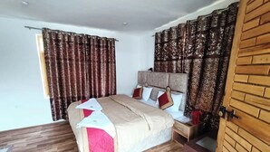 Un dormitorio ordenado con cama, mesita de noche y puerta de madera.