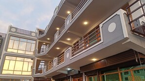 Un edificio de varios pisos con balcones, ventanas amplias y un diseño arquitectónico moderno.