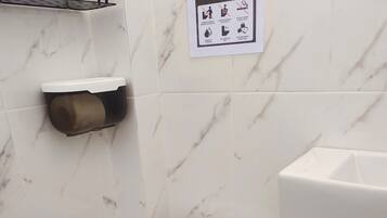 Chuveiro, toalhas de banho, sabonete, papel higiênico