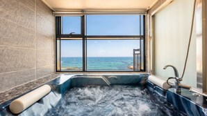 A bathtub with a view of the ocean through a large window. - Capella Oceanview Spa Resort Goseong (Goseong)