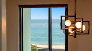 Blick durch ein Fenster auf ein klares Meer und einen Bojen im fernen.