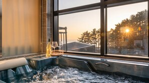 Un bain à remous avec vue sur les arbres et un bâtiment.