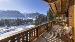 Eine Holzterrasse mit Blick auf schneebedeckte Berge.