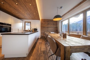 Una cocina moderna con techo de madera, armarios blancos y una isla grande.