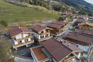A cluster of chalet-style buildings with sloped roofs, wooden balconies, and a central courtyard.