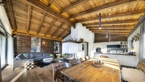 Amplia sala de estar con un gran comedor de madera, asientos de cuero y un alto techo de madera.