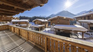 A wooden chalet with a balcony overlooking a snowy mountain landscape. - Chalet with sauna, Neukirchen (Neukirchen)