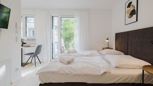 Une chambre d’hôtel moderne, dotée d’un grand lit, d’un bureau et d’une chaise.