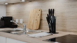 Une cuisine moderne dotée d’un plan de travail en bois, d’un évier, d’une planche à découper et d’un bloc à couteaux.
