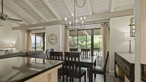 A spacious kitchen with a central island, dining area with chairs, and a large window providing natural light. - Lake Escape w/ Deck & Patio (Horseshoe Bay)