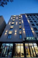 Un hotel con fachada moderna, amplias ventanas y una entrada visible con puertas de vidrio.