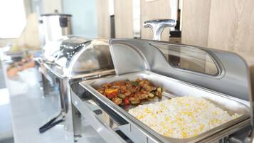 A buffet with a variety of dishes including rice and stir-fried vegetables.