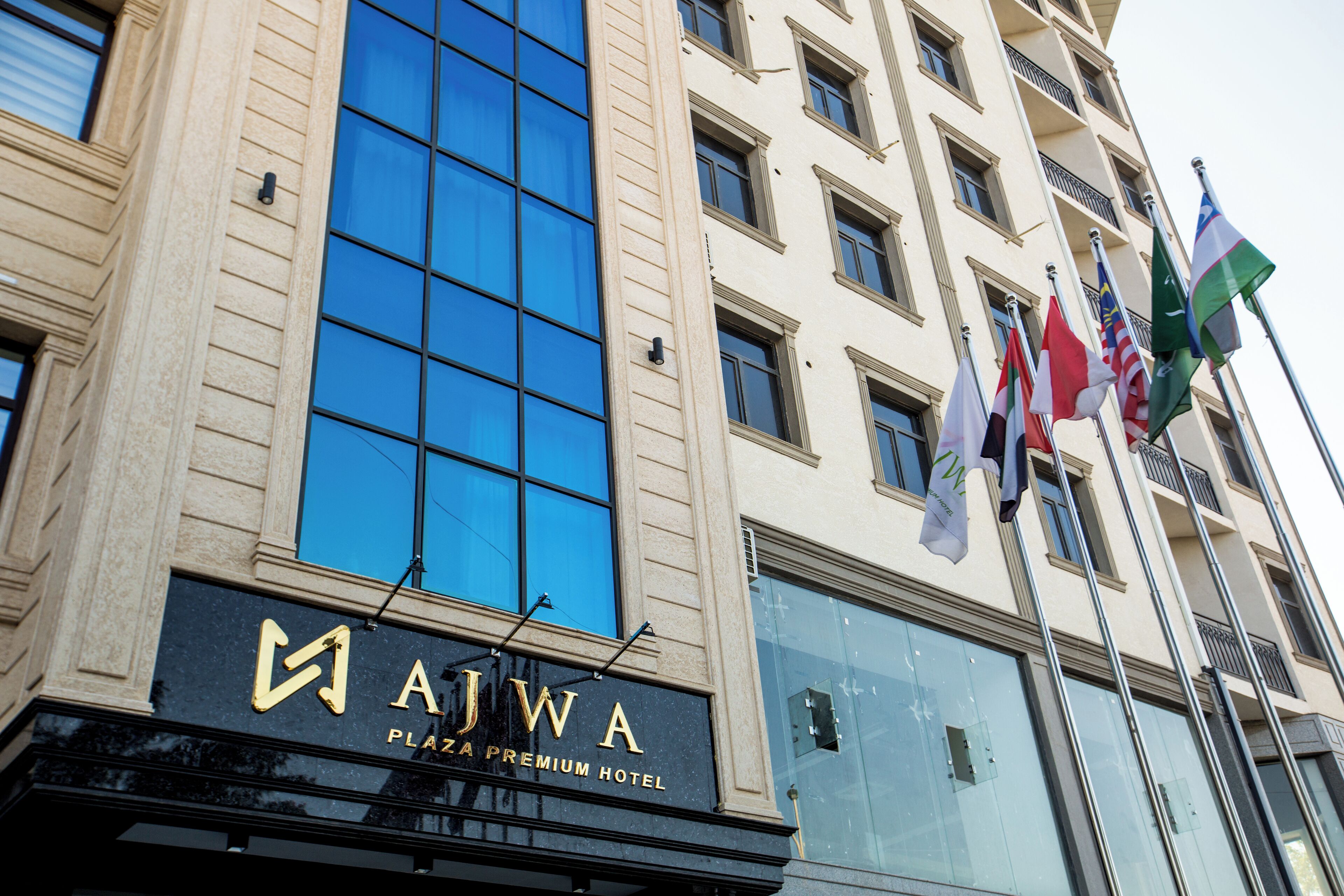 Un immeuble sur lequel on peut lire l’inscription : « Hôtel de luxe AJWA Plaza ».