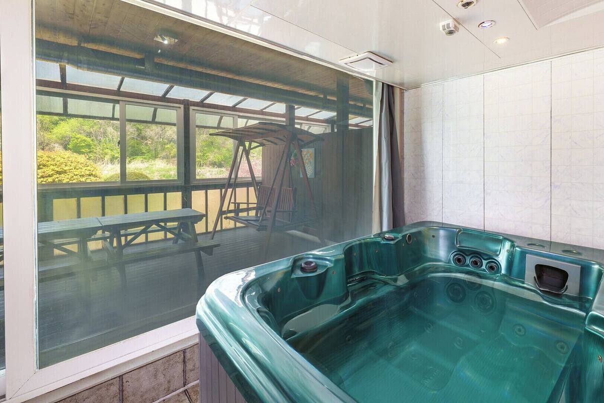 Un jacuzzi con vistas a un patio y un porche cubierto.