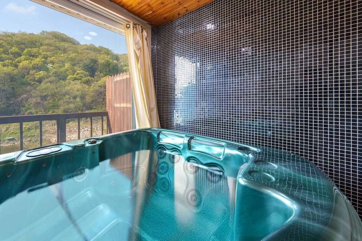 Un jacuzzi con vistas a una ladera boscosa.