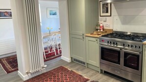 Une cuisine moderne dotée d’une cuisinière, d’un four et d’une hotte de ventilation de grande taille, le tout intégré.