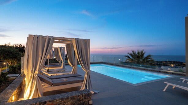 A poolside area with a pergola and lounge chairs, overlooking a body of water. - Villa La mer de Crete - private pool & sew view (Agia Pelagia)