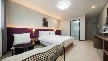 A hotel room with a bed, bedside tables, a chair, a desk, and a mirror.