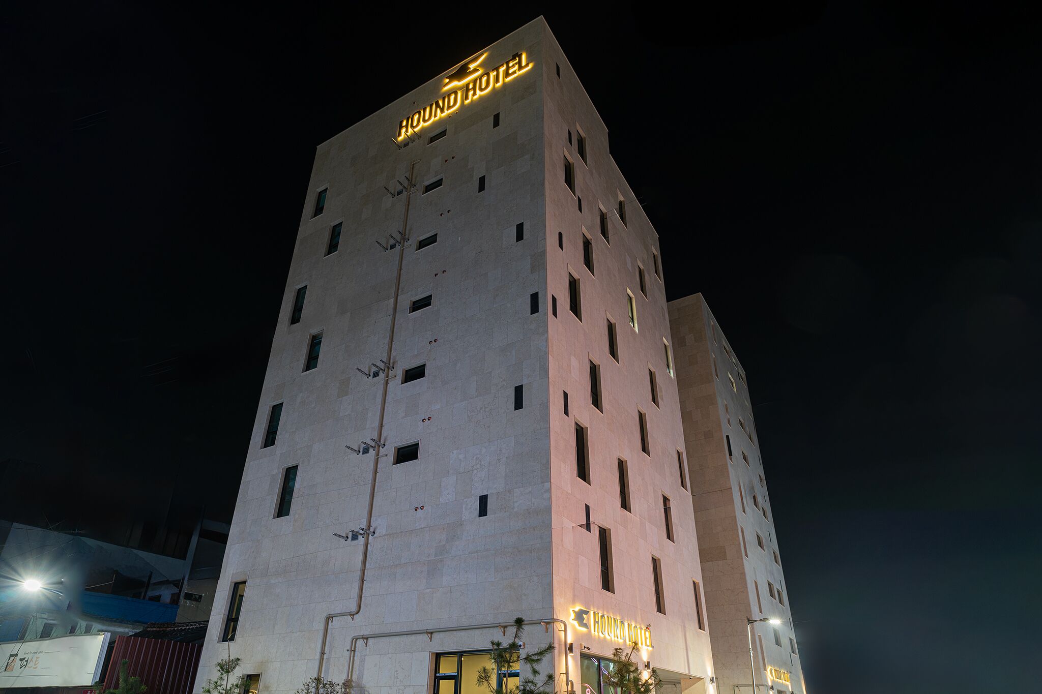 A tall hotel building with a sign that reads "HOUND HOTEL" at the top.