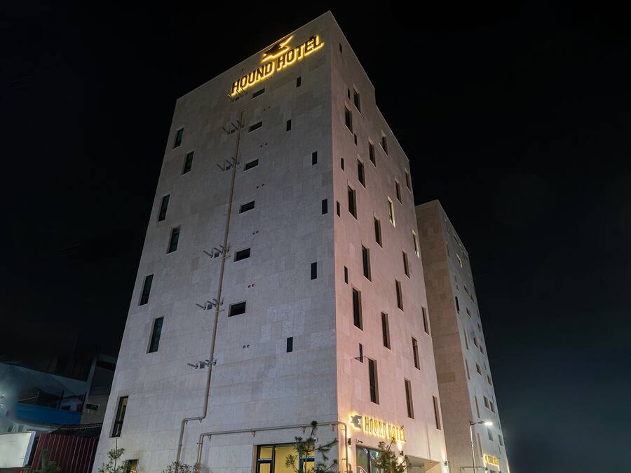 A tall hotel building with a sign that reads "HOUND HOTEL" at the top.