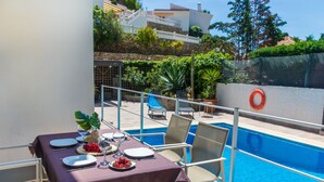 A dining area with a table set for two, overlooking a swimming pool. - Bugambilla by Interhome (Almuñécar)