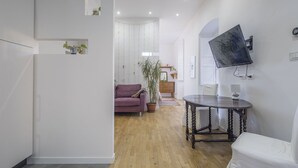 A modern living room with a purple sofa, a round wooden table, and a mounted TV. - Central Cozy Nest With Parking, Bogliasco (Bogliasco)