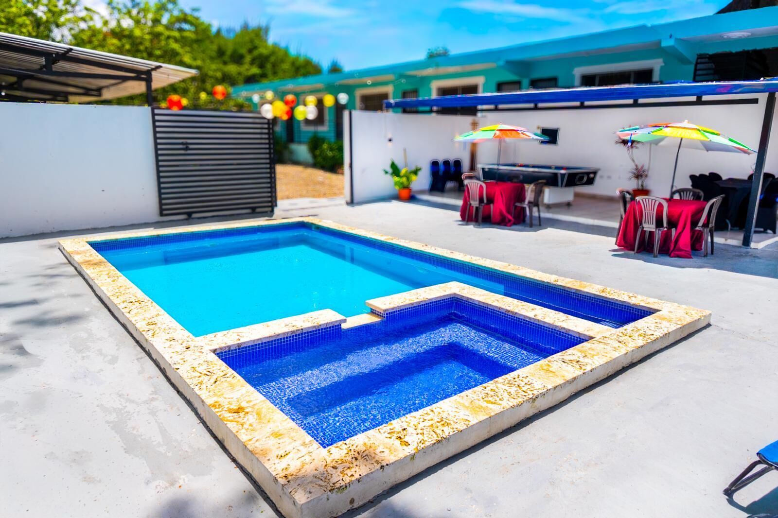 Una piscina rectangular con borde de azulejos, rodeada por un deck de concreto.