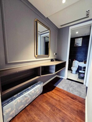 Bathroom features a large mirror, vanity, and a toilet.
