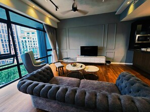 Relax in this stylish living room with a plush sofa, flat-screen TV, and city views.