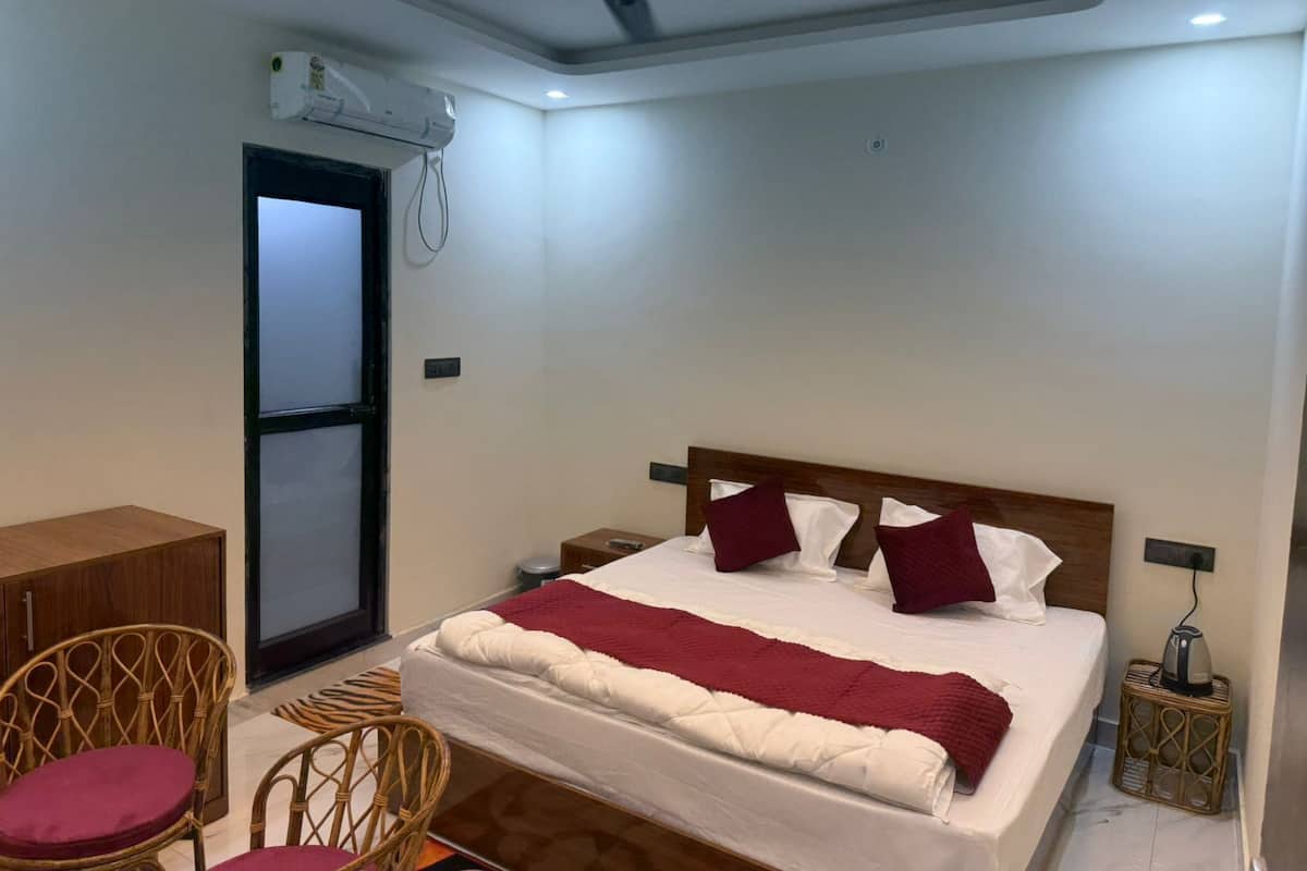 A bedroom with a bed, a ceiling fan, a desk, and a chair.