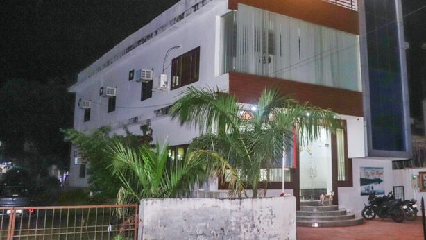 A multi-story building with a white facade, air conditioning units, and a staircase leading to the entrance. - Hotel Taj Royal (Agra)