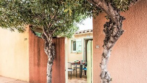 Un callejón estrecho con un sendero bordeado de árboles que lleva a un edificio con el número 379.
