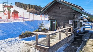 A wooden building with a sloped roof, a small entrance, and a signboard. - Simonhöhe by Interhome (Sankt Urban)
