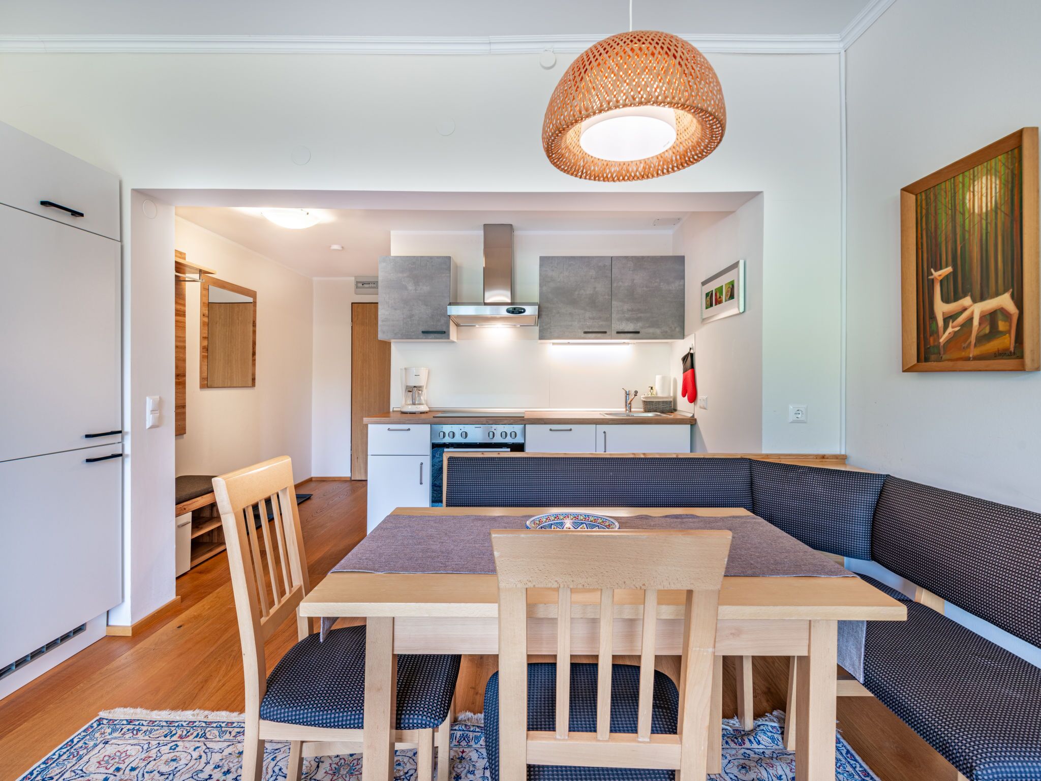 Een moderne keuken met een eethoek, inclusief een tafel en bankjes.
