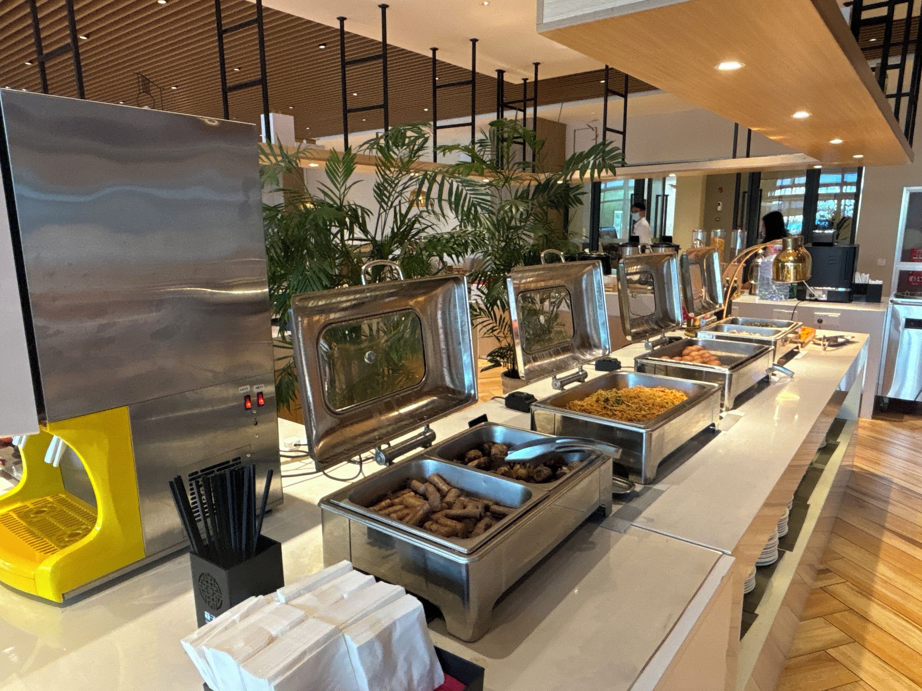 A buffet setup with various food stations, including a grill, a salad bar, and a meat station.