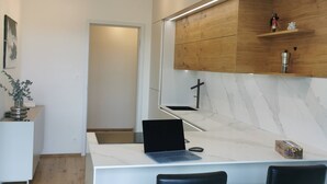 A modern kitchen with a marble countertop, two black chairs, and a laptop. - free Parking, center location, Nuslesky Pivovar sunset balcony home (Hlavní město Praha)