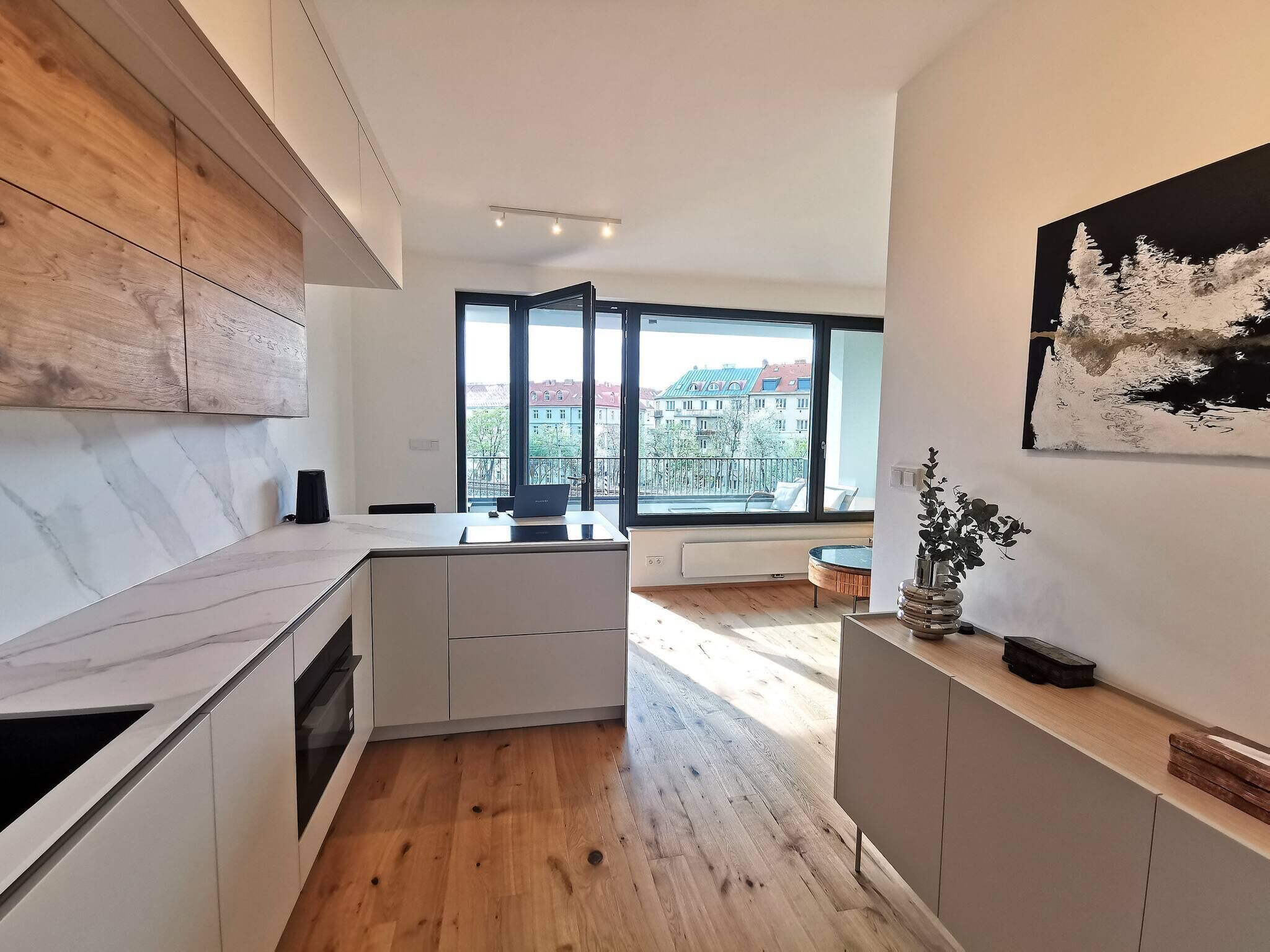 Une cuisine moderne dotée d’une grande fenêtre, de meubles en bois et d’un design minimaliste.