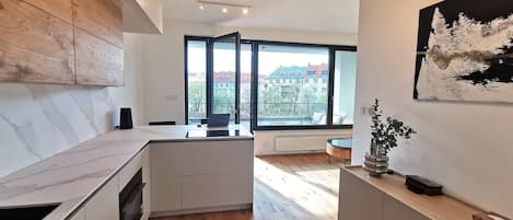 Une cuisine moderne dotée d’une grande fenêtre, de meubles en bois et d’un design minimaliste.