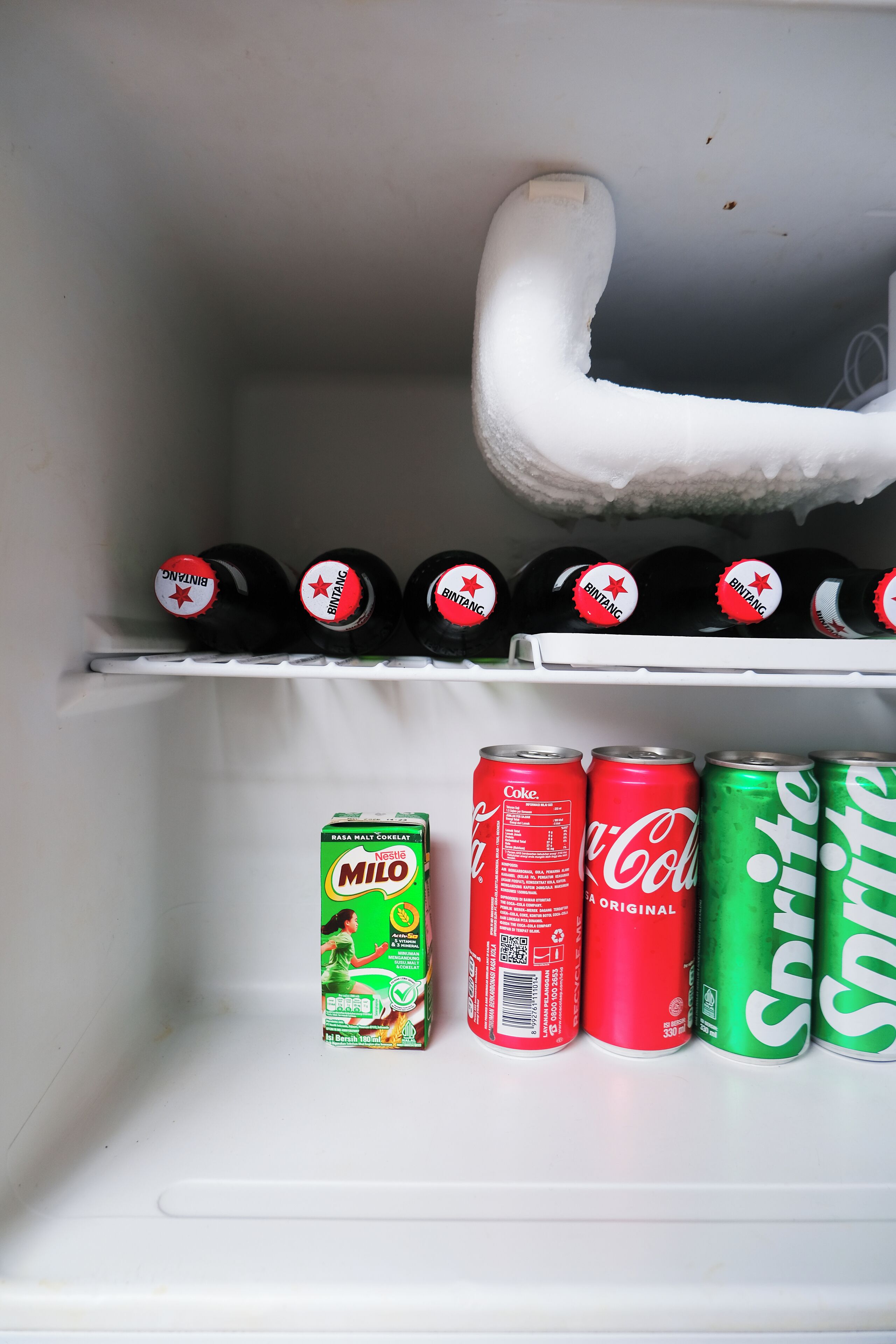A refrigerator with bottles and cans of beverages.