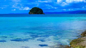 A clear view of a turquoise sea with a small island in the distance. - villa LIFE INDAH sumuide (Nago)