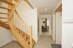 A wooden staircase leading to a dining area with a table and chairs. - Beachfront vacation rental with a balcony, access to the pool and sauna - Rex Rugia - Rex Rugia (Göhren)