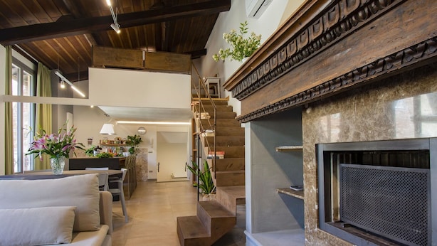 A spacious living area with a fireplace, a staircase, and a dining area.