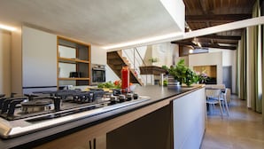 A modern kitchen with a central island, built-in oven, and stainless steel appliances.